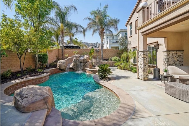 view of pool with pool water feature and a patio