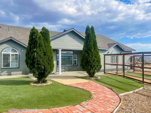 back of house with a lawn and a patio area