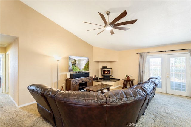 living room featuring light colored carpet, lofted ceiling, a wood stove, and french doors