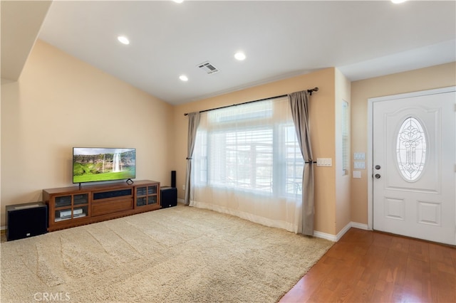 foyer entrance featuring lofted ceiling and hardwood / wood-style flooring