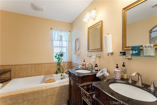 bathroom with tiled tub and vanity