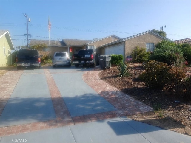 exterior space with driveway, an attached garage, and stucco siding