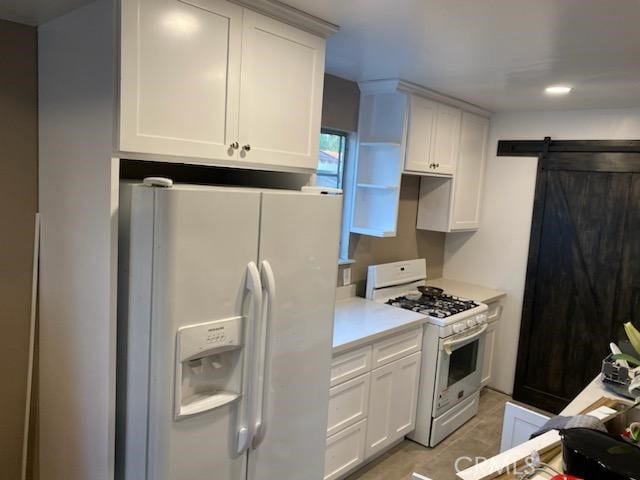 kitchen featuring white appliances, a barn door, white cabinetry, and light countertops