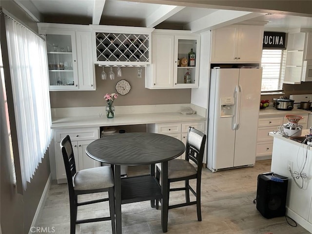 kitchen with white appliances, glass insert cabinets, white cabinets, and light wood-style floors