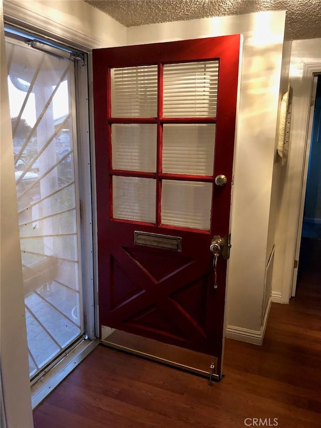 entryway with a textured ceiling and wood finished floors