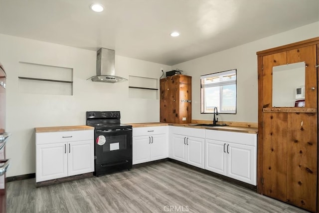 kitchen featuring black range with electric stovetop, white cabinets, sink, wall chimney range hood, and hardwood / wood-style flooring