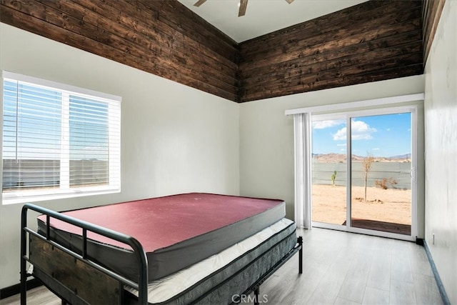 bedroom with light hardwood / wood-style flooring, multiple windows, access to exterior, and ceiling fan