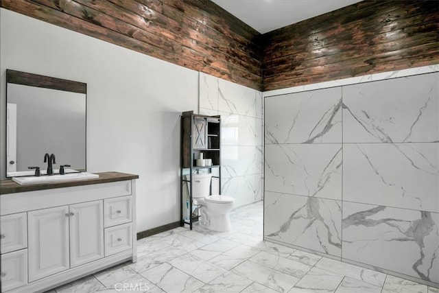 bathroom featuring vanity, tile walls, and toilet