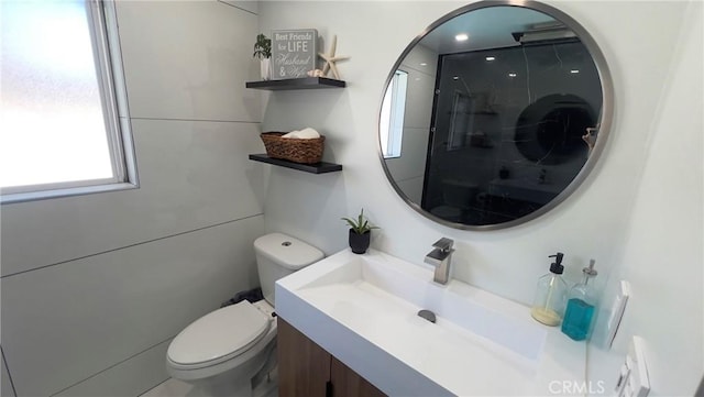 bathroom featuring walk in shower, vanity, and toilet