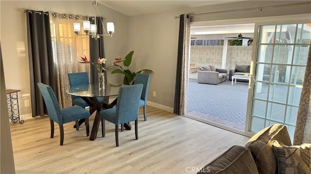 dining space featuring an inviting chandelier and light hardwood / wood-style flooring