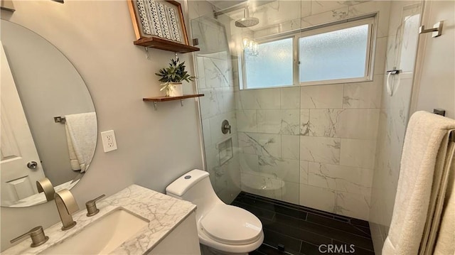 bathroom with vanity, a tile shower, and toilet