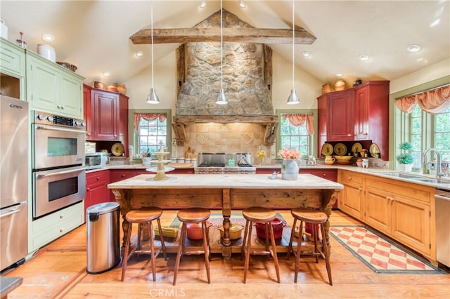 kitchen featuring appliances with stainless steel finishes, light wood-type flooring, sink, and a wealth of natural light