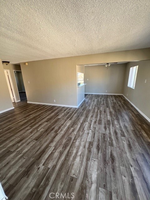 unfurnished living room featuring a textured ceiling, dark hardwood / wood-style flooring, and ceiling fan