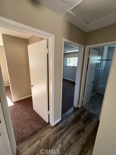 corridor featuring a textured ceiling and dark hardwood / wood-style floors