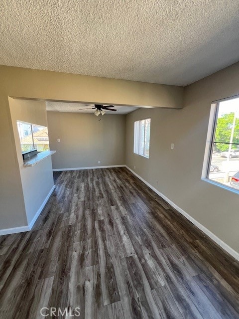 unfurnished room with dark hardwood / wood-style flooring, ceiling fan, and plenty of natural light