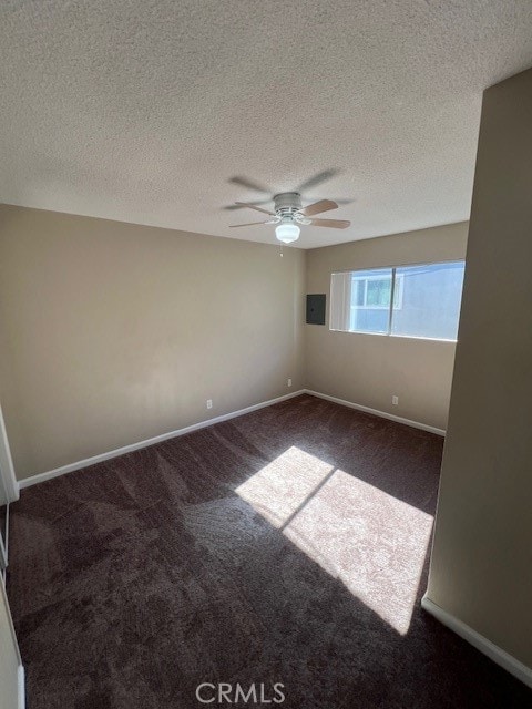 unfurnished room featuring ceiling fan, a textured ceiling, carpet flooring, and electric panel