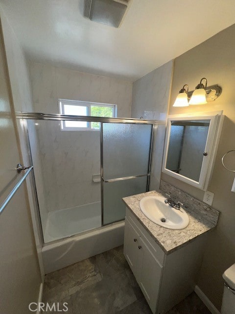 full bathroom featuring toilet, vanity, and combined bath / shower with glass door