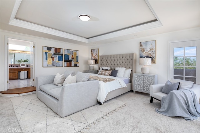 carpeted bedroom with a raised ceiling and ensuite bath