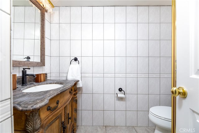 bathroom with tile walls, tile patterned floors, vanity, and toilet