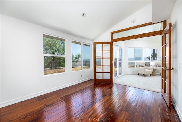 empty room with french doors, dark hardwood / wood-style floors, and high vaulted ceiling