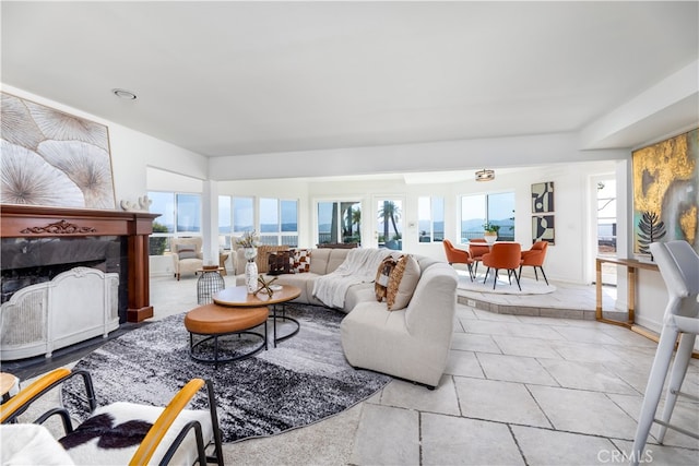 living room with a high end fireplace and light tile patterned floors