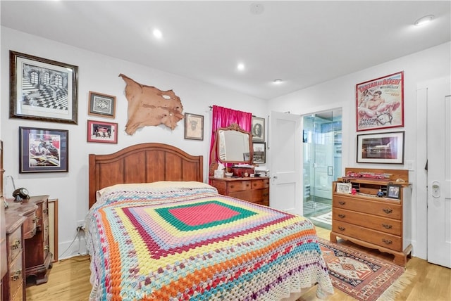 bedroom with light wood-type flooring and connected bathroom