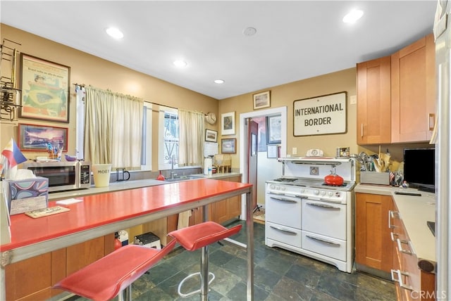 kitchen featuring white range oven and sink