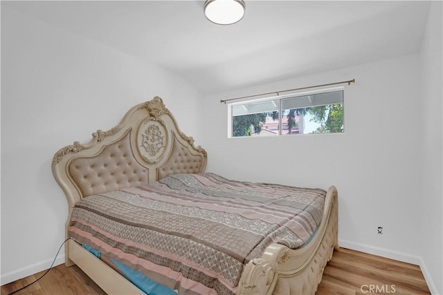 bedroom with light hardwood / wood-style flooring and lofted ceiling