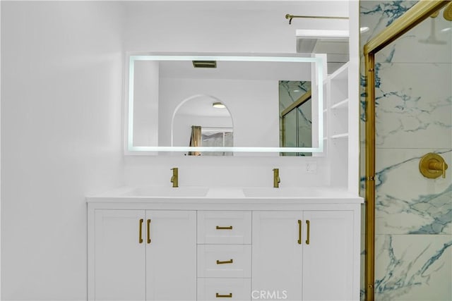 bathroom featuring an enclosed shower and vanity