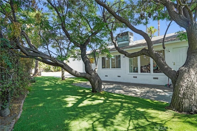 view of home's exterior with central AC unit and a lawn