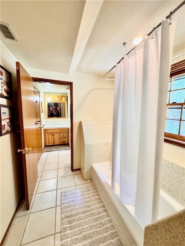 bathroom featuring vanity, shower / tub combo, tile patterned flooring, and a textured ceiling