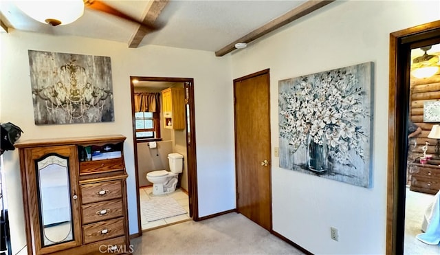 carpeted bedroom with ensuite bath, beamed ceiling, and ceiling fan