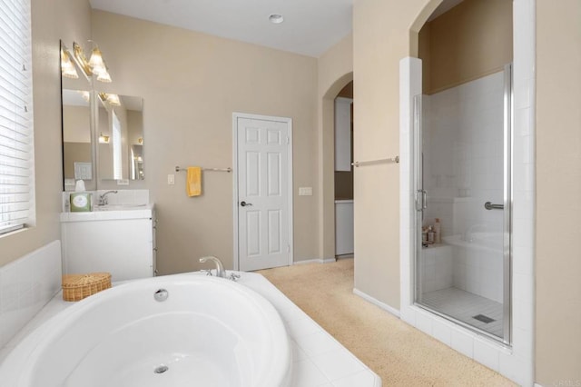 bathroom featuring a bath, a stall shower, and vanity