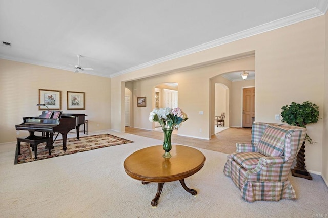 sitting room featuring arched walkways, crown molding, visible vents, a ceiling fan, and baseboards