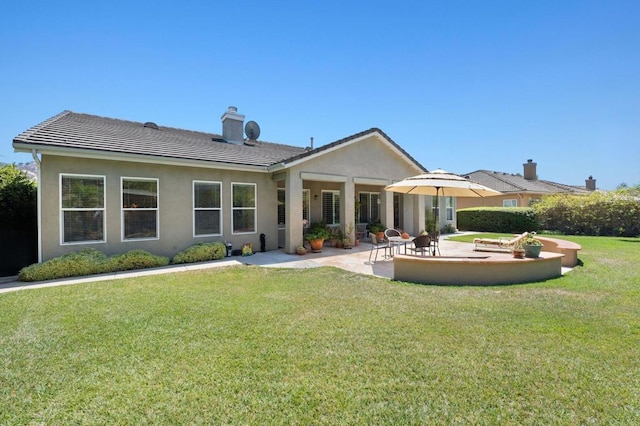 back of property featuring a patio area, a tile roof, stucco siding, and a yard