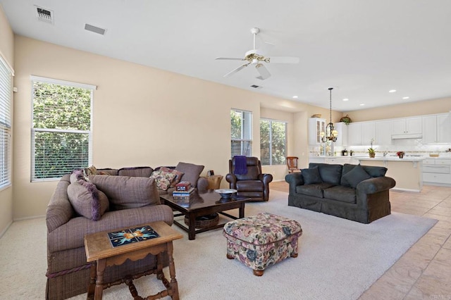 living area with ceiling fan with notable chandelier, visible vents, and recessed lighting