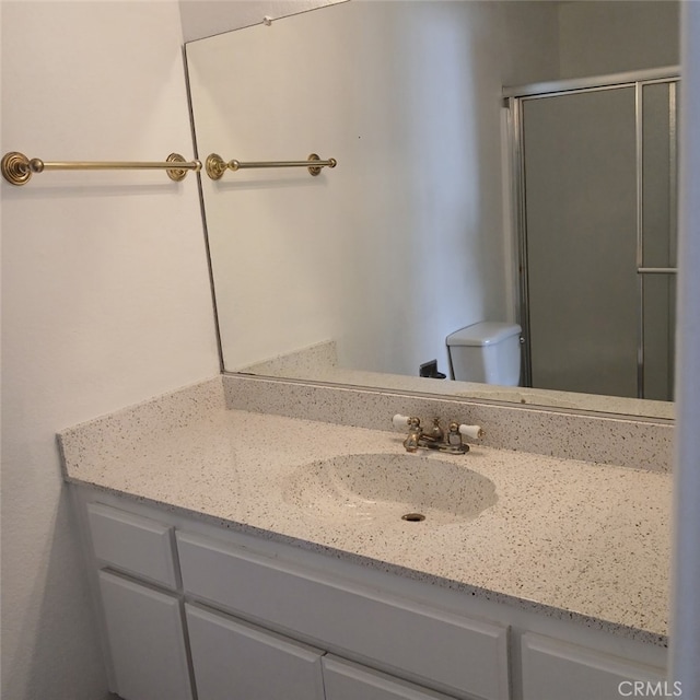 bathroom featuring toilet, walk in shower, and vanity