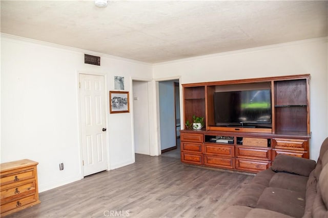 living room featuring hardwood / wood-style flooring and crown molding