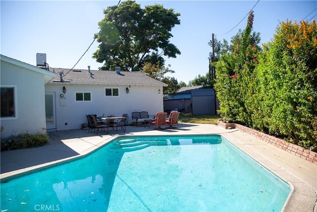 view of pool with a patio, an outdoor hangout area, and a storage unit