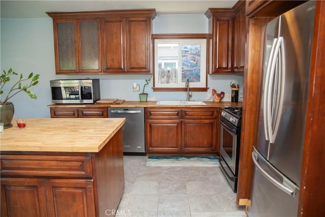 kitchen with sink, wooden counters, and appliances with stainless steel finishes