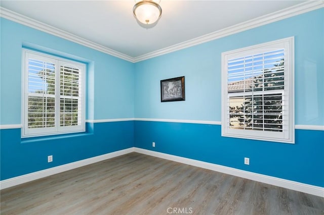 unfurnished room featuring hardwood / wood-style floors and crown molding