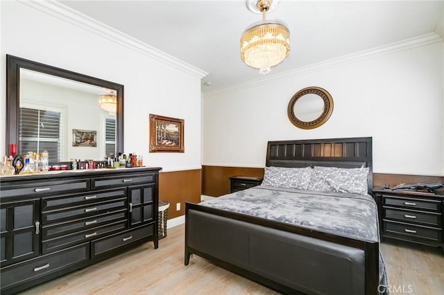 bedroom featuring light hardwood / wood-style floors, ornamental molding, and an inviting chandelier