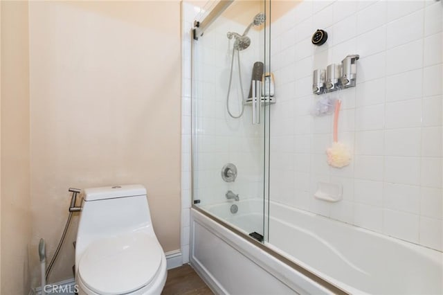 bathroom with combined bath / shower with glass door and toilet