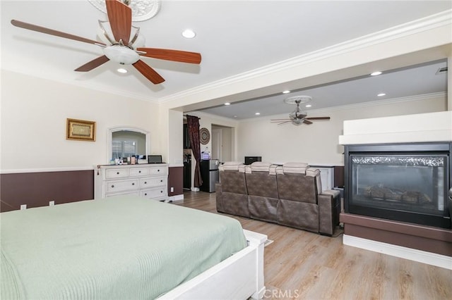 bedroom featuring ceiling fan, light wood-type flooring, and ornamental molding