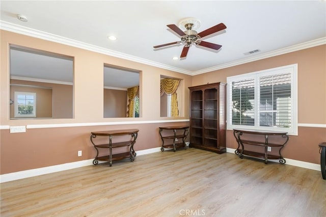 interior space featuring ceiling fan, ornamental molding, and light wood-type flooring