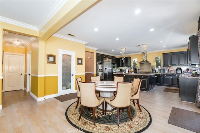 dining space with light wood-type flooring and crown molding