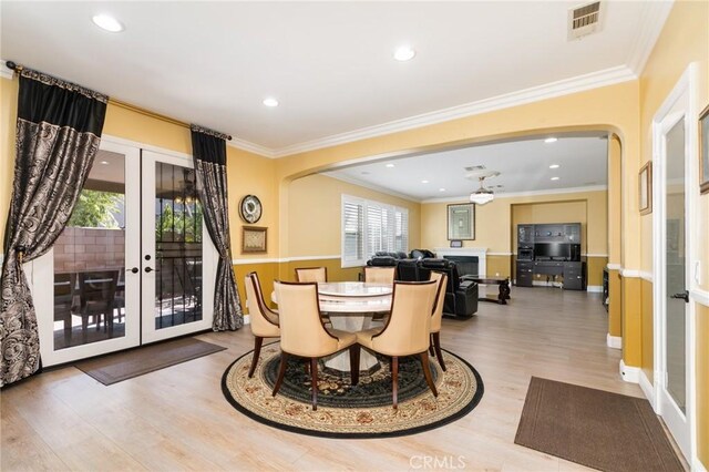 dining area with french doors, light hardwood / wood-style flooring, ceiling fan, and crown molding