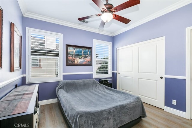 bedroom featuring ceiling fan, hardwood / wood-style floors, and ornamental molding