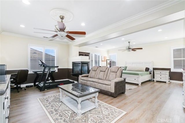 living room featuring light wood-type flooring, a wealth of natural light, and crown molding