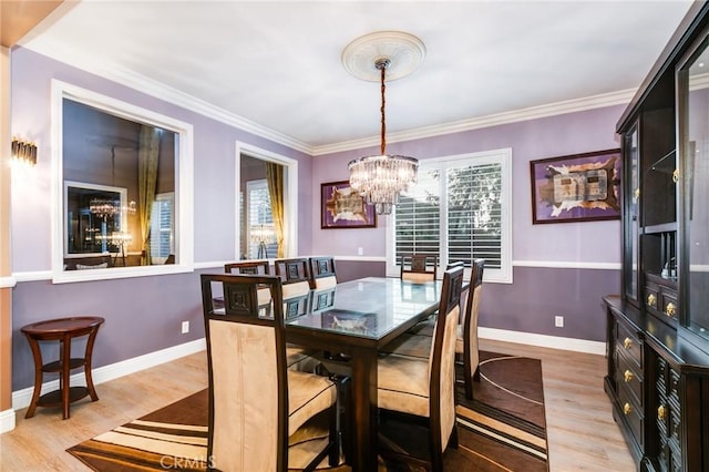 dining space featuring a chandelier, light hardwood / wood-style flooring, and crown molding